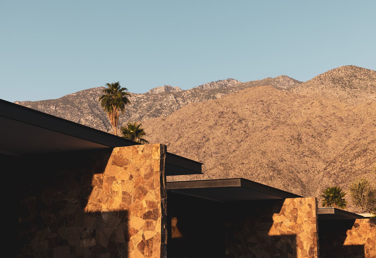 Mountains and palm trees overlooking the stone walls near the pool at our Palm Springs resort.